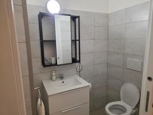 a bathroom with a sink and a toilet and a mirror at Alloggio turistico di Stefano in Lido di Ostia