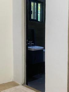 a bathroom with a sink and a window at TOBY HOUSE SiARGAO in Catagnan