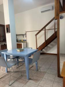a blue table and chairs in a room with a staircase at Appartamento nel cuore di Lampedusa in Lampedusa