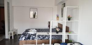 a bedroom with a bed and a white shelf at MAGIC Studio - Ultracentral Ploiesti in Ploieşti