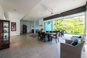 a dining room and living room with a table and chairs at PapaCrab Boutique Guesthouse in Kamala Beach