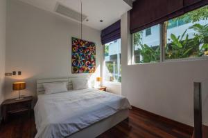 a bedroom with a bed and a large window at PapaCrab Boutique Guesthouse in Kamala Beach