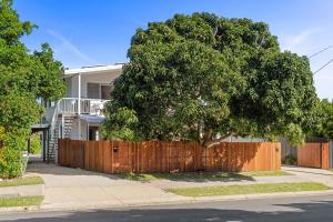 a wooden fence in front of a house with a tree at The Palms in Coolum Beach - Unit A in Coolum Beach