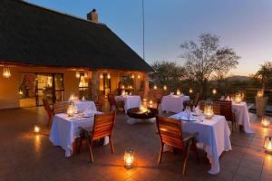 a restaurant with white tables and chairs and lights at Sable Ranch Thaba Khaya Lodge in Brits