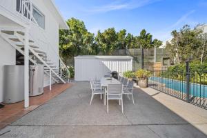 a patio with a table and chairs next to a pool at The Palms in Coolum Beach - Unit B in Coolum Beach