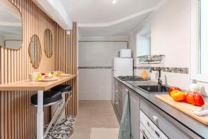 eine Küche mit einer Theke und einem Tisch mit Obst in der Unterkunft Escale Zen - Sauna Exclusif & Terrasse Privée - Idéal Pro & Couple - Piscine - 5min Port Toulon & Plage - WIFI HD - Expérience premium "Dans une bulle" in Toulon