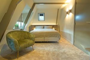 a bedroom with a bed and a chair at Boutique Hotel AEST Terschelling in Hoorn