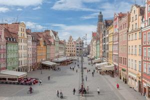 a group of people walking around a street with buildings at NiceOne Apartment Number 10 - W samym Centrum! in Wrocław