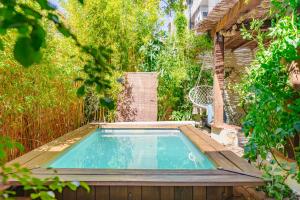 a small swimming pool in a garden with a chair at L'Escale - Idéal Couple & Pro en Quête d'un Moment Détente et se Ressourcer - Sauna Exclusif & Terrasse Privée - Piscine - WIFI HD - 5min Port Toulon & Plage in Toulon