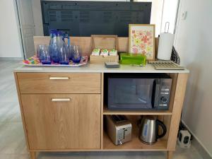 a wooden desk with a microwave and a tv at Le Plain-pied du Pêcheur - Maison avec terrasse entre Loire, Via Velay et Le Puy in Brives-Charensac
