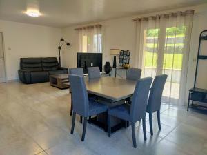 a dining room with a table and chairs and a couch at Le Plain-pied du Pêcheur - Maison avec terrasse entre Loire, Via Velay et Le Puy in Brives-Charensac