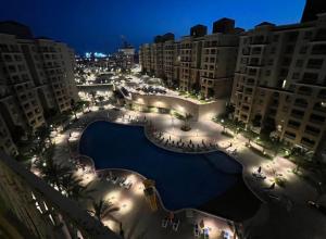 a large swimming pool in a city at night at Aqwa view in El Alamein