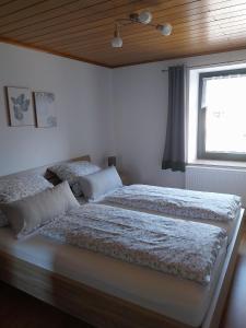 two beds in a bedroom with a window at Ferienwohnung EifelReich in Dreiborn +16 photos