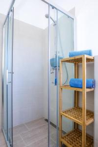 a bathroom with a glass shower with blue towels at Steinhaus Mediterra mit Pool & Meerblick - Lukoran, Insel Ugljan bei Zadar in Lukoran