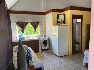 a kitchen with a white refrigerator and a sink at Tihimani Lodge Village in Rangiroa
