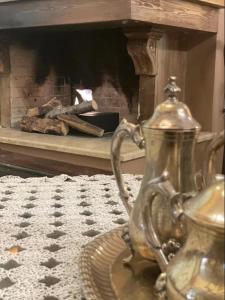 un bollitore d'argento su un tavolo con un camino di Mountain View a Synikia Mesi Trikalon Altre 18 foto