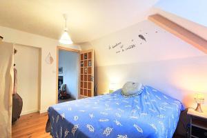 a bedroom with a bed with a blue comforter at Spacious cocoon near the sea in Saint Malo