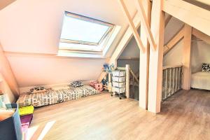 a attic room with a bed and a window at Spacious cocoon near the sea in Saint Malo +1 photo