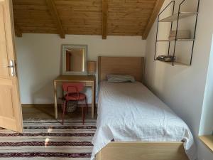 Un dormitorio con una cama, un escritorio y una silla. en Two Pines Summer House in Tihany, Sajkod, en Tihany