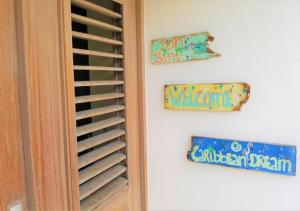 two signs on a wall next to a door at Villa Caribbean Dream Bonaire in Kralendijk