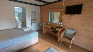 a bedroom with a bed and a desk and a television at Gloucester Motel Pemberton Manjimup in Pemberton