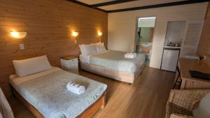 ein kleines Zimmer mit 2 Betten und einer Küche in der Unterkunft Gloucester Motel Pemberton Manjimup in Pemberton