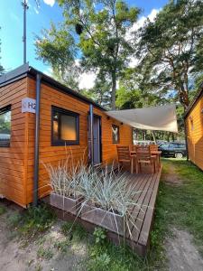 a wooden cabin with a deck with a table and chairs at Sopot 34 przy plaży in Sopot