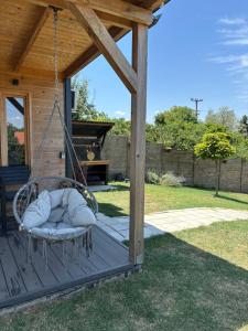 a swing on a porch of a house at Woody House with pool in Krčedin