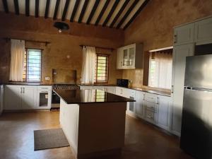 a large kitchen with white cabinets and a black counter top at Katiti N'tamu Lamu in Lamu