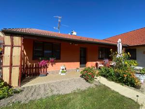 a house with a patio and a yard with flowers at Apartment Anna in Šakvice