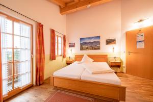 ein Schlafzimmer mit einem Bett und einem großen Fenster in der Unterkunft Berggasthof Hotel Duftbräu I Ruhige Alleinlage I Mitten im Grünen in Samerberg + 36 Fotos
