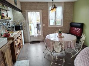 une cuisine avec une table et des chaises dans une pièce dans l'établissement le cottage, à Martin-Église