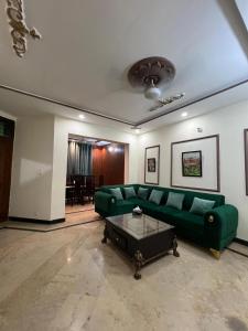 ラホールにあるLuxury comfort homeの緑のソファとテーブルのあるリビングルーム