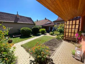 a backyard with a garden with flowers and a house at Apartment Anna in Šakvice +4 photos