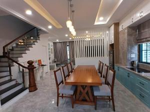 a kitchen with a table and chairs and a staircase at Villa Nova Quân Nhân 4 in Bình Tú