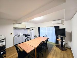 a kitchen and dining room with a wooden table and chairs at Vacation House 2 in Funabashi