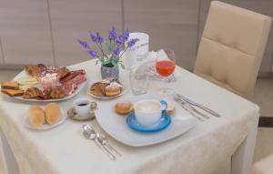 stół z dwoma talerzami produktów śniadaniowych i napojów w obiekcie B&B Paradiso w mieście San Salvo