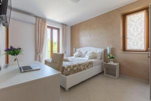 a bedroom with a bed and a desk with a laptop at B&B Paradiso in San Salvo