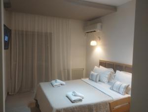 a bedroom with a large white bed with towels on it at Thassos Hotel in Pefkari