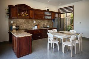 a kitchen with a table and some white chairs at Yên Riverside Villa - Homestay Huế in Hue