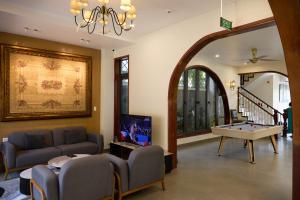 a living room with a couch and a pool table at Yên Riverside Villa - Homestay Huế in Hue