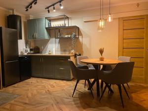 Una cocina con mesa y sillas y un refrigerador. en Sielsko Anielsko Apartament, en Zawoja