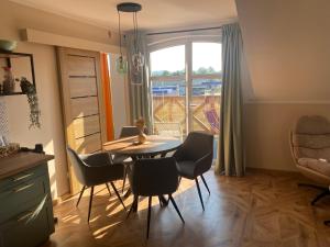 Un comedor con mesa y sillas y una ventana. en Sielsko Anielsko Apartament, en Zawoja