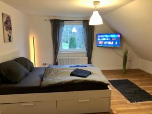 a bedroom with a bed with a tv on the wall at Ferien im Schwarzwald Ferienwohnung Freiamt in Freiamt