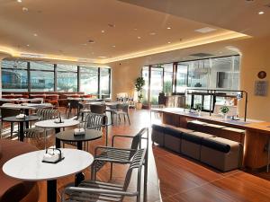 un restaurant avec des tables, des chaises et des fenêtres dans l'établissement Citadines Gongbei Zhuhai, à Zhuhai