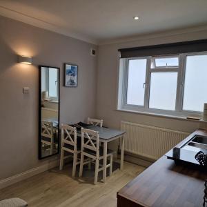 a dining room with a table and chairs and windows at Family-Friendly Bungalow near Salisbury in Alderbury