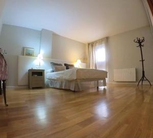 a bedroom with a bed and a wooden floor at Mirasierra Ático in Jaén