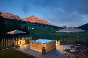a deck with a hot tub and two umbrellas at Chalet La Varieté in La Villa