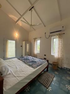 a bedroom with a large bed and two windows at Isaikkoodu in Turavūr +20 photos