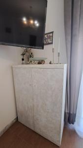 a white cabinet with a television on top of it at La perla di Caserta 2 in Caserta
